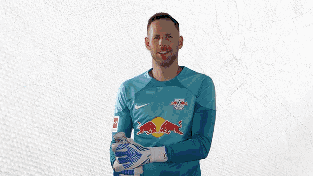 a soccer player wearing a blue jersey with a red bull on it
