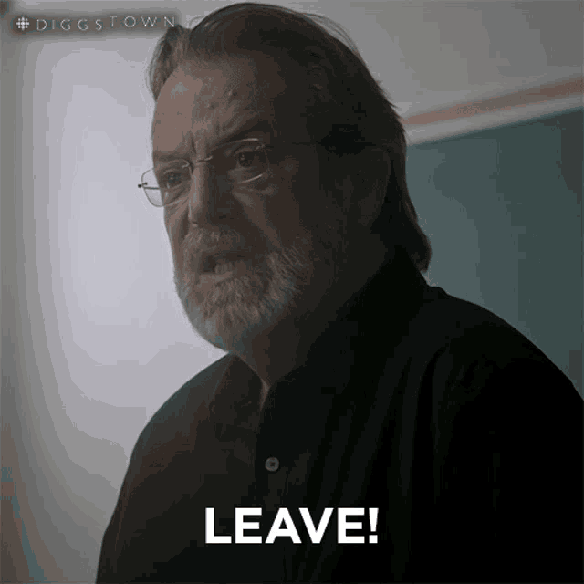 a man with glasses and a beard has the word leave in front of him