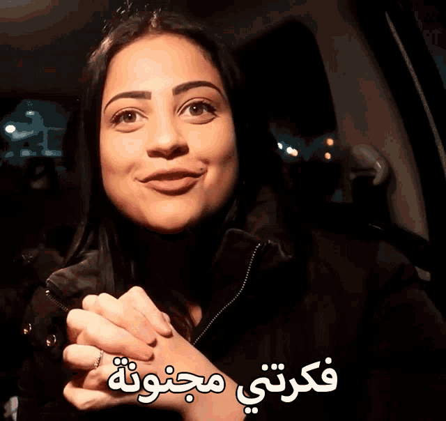a woman in a car with arabic writing on the bottom