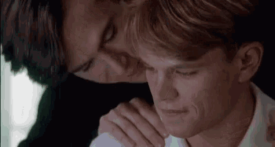 a couple of men are hugging each other and one of them is touching the other 's neck .