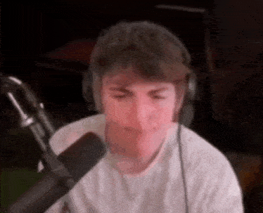 a man is wearing headphones and talking into a microphone .