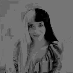 a black and white photo of a woman with long hair and a wig .