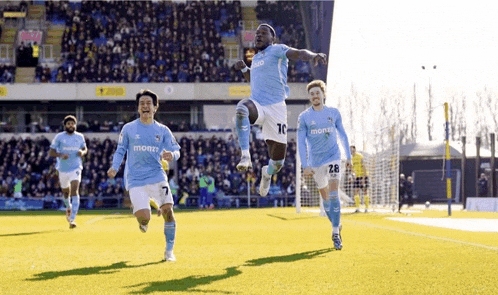 a soccer player wearing a jersey that says monzo jumps into the air