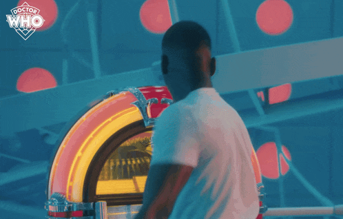 a man is dancing in front of a jukebox that says doctor who on the bottom
