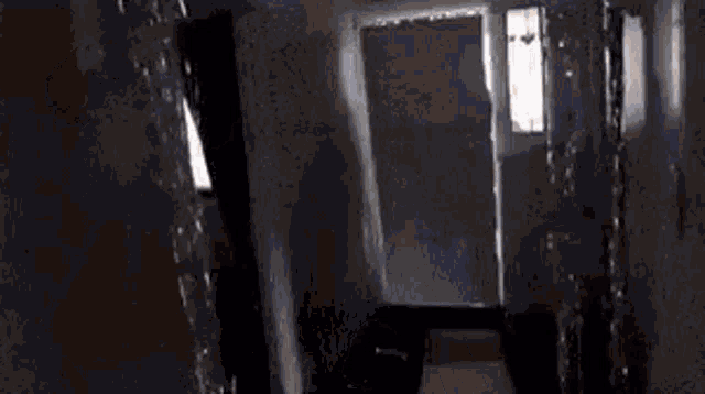 a man is carrying a large piece of wood down a hallway .