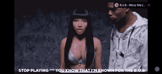 a woman in a bra stands next to a man in a white jacket and says stop playing