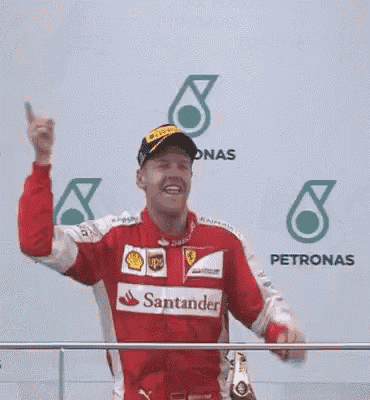 a man in a red and white ferrari uniform is standing on a balcony .
