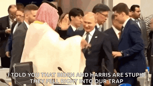 a group of men in suits and ties are standing around a man in a sheikh 's robe .