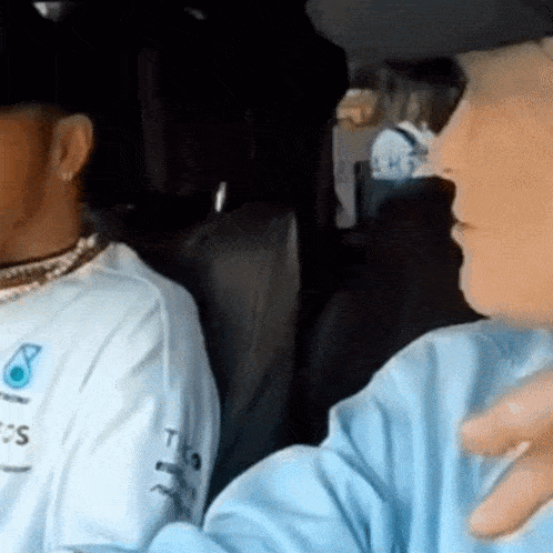 a man wearing a white shirt with the word petronas on the front