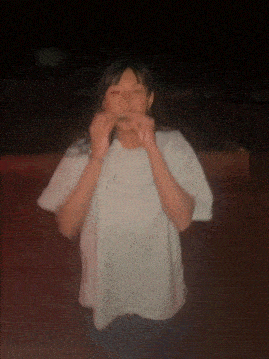 a blurry picture of a person wearing a white t-shirt with the letter c on it