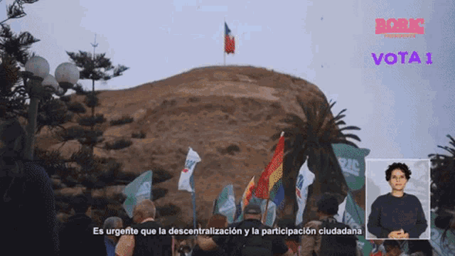 a group of people holding flags in front of a sign that says vota1