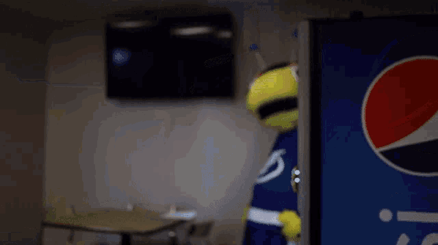 a mascot is standing in front of a pepsi cooler