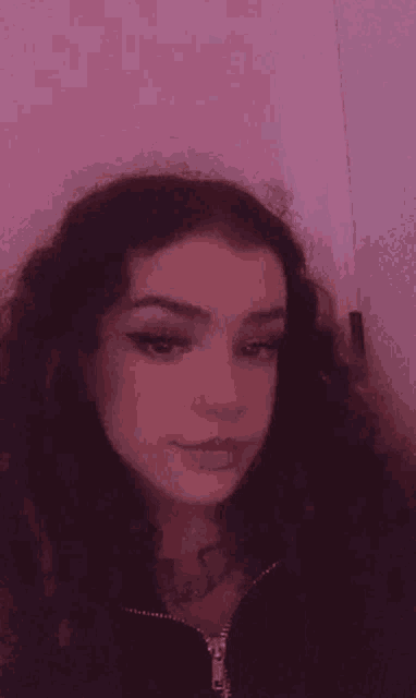 a close up of a woman 's face with a pink background and a pink background .