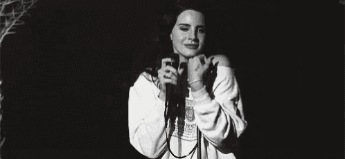 a black and white photo of a woman wearing a white sweatshirt and smiling .