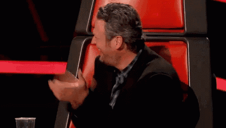 a man is sitting in a chair with his hands in the air .