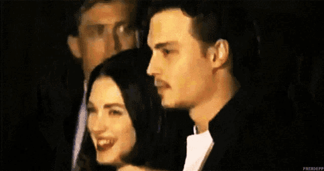 a man and a woman are standing next to each other in a blurry photo