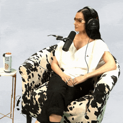 a woman wearing headphones sits in a chair in front of a microphone next to a can of french toast