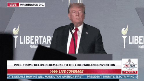 donald trump is giving a speech in front of a washington d.c. sign