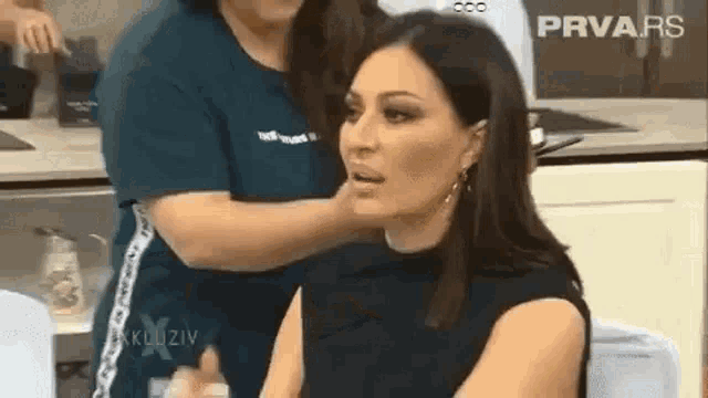 a woman is getting her makeup done by a makeup artist .
