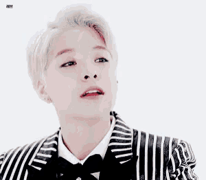 a woman wearing a black and white striped jacket and bow tie