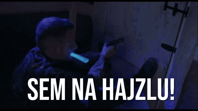 a man holding a gun with a glow stick in his mouth and the words sem na hajzlu on the bottom