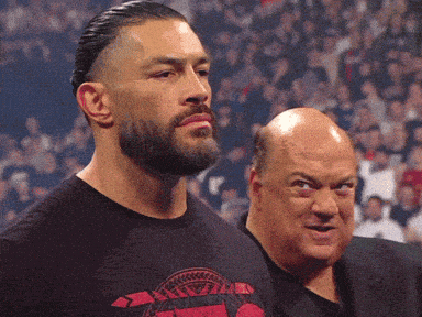 a man with a beard wears a shirt that says ' roman reigns ' on it