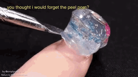 a close up of a person 's finger with a bottle of nail polish on it