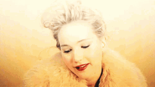 a woman with white hair and red lips is wearing a white fur coat