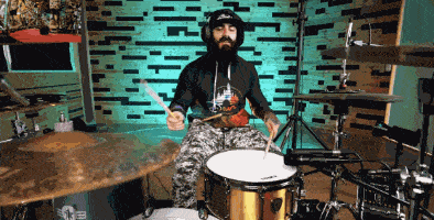 a man playing a drum set with a shirt that says ' slayer ' on it
