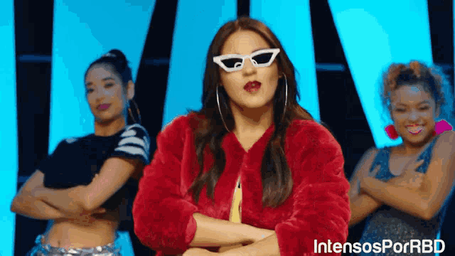 a woman in a red fur coat and white sunglasses stands in front of two other women with intensosporrbd written on the bottom