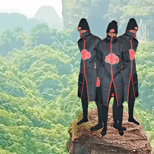 a group of people standing on top of a rock wearing black and red outfits with clouds on them