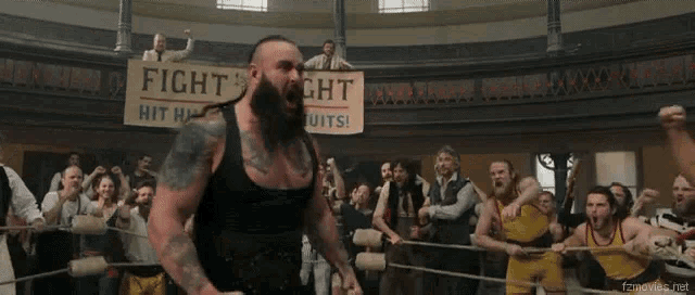 a man in a boxing ring stands in front of a sign that says fight him in