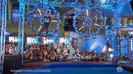 a man is flying through the air in front of a crowd of people .