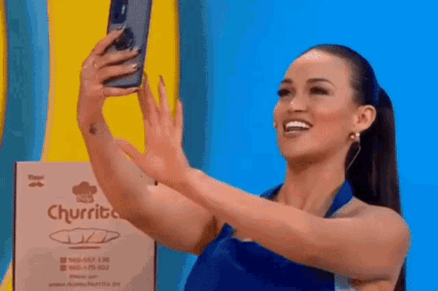 a woman is taking a selfie with her cell phone on a stage .