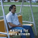 a man is sitting on a swing in a park waiting for mella stream .