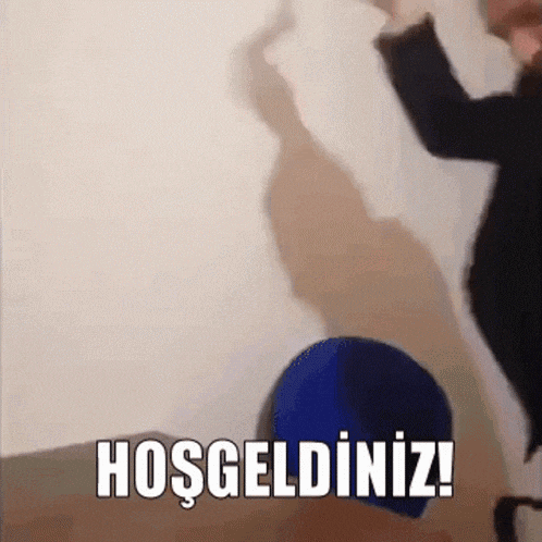 a person standing in front of a wall with the words hoşgeldiniz