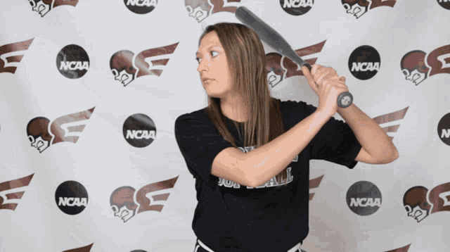a woman holding a baseball bat in front of a ncaa background