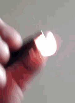 a close up of a person lighting a lighter with the letter w on it
