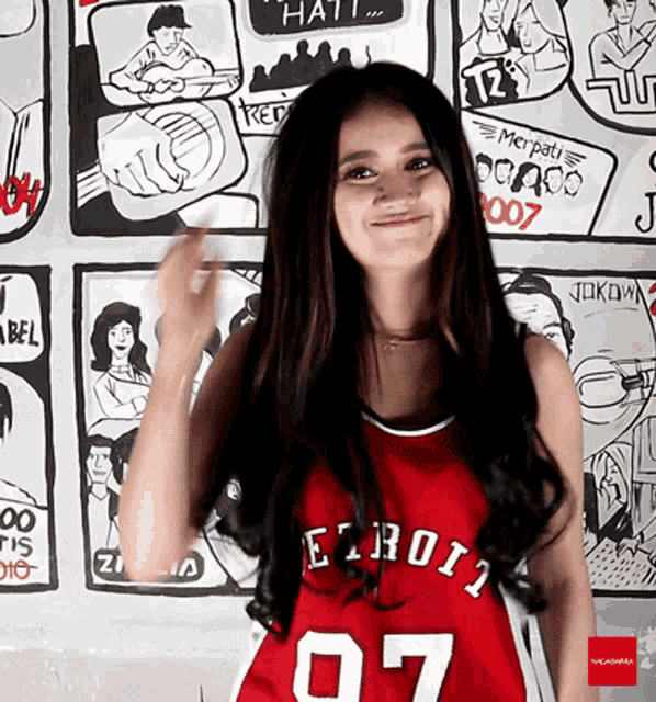 a woman wearing a red jersey that says detroit on it