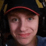 a man wearing headphones and a baseball cap is smiling .