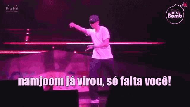 a man in a white shirt is dancing on a stage with the words namjoom ja virou so falta você