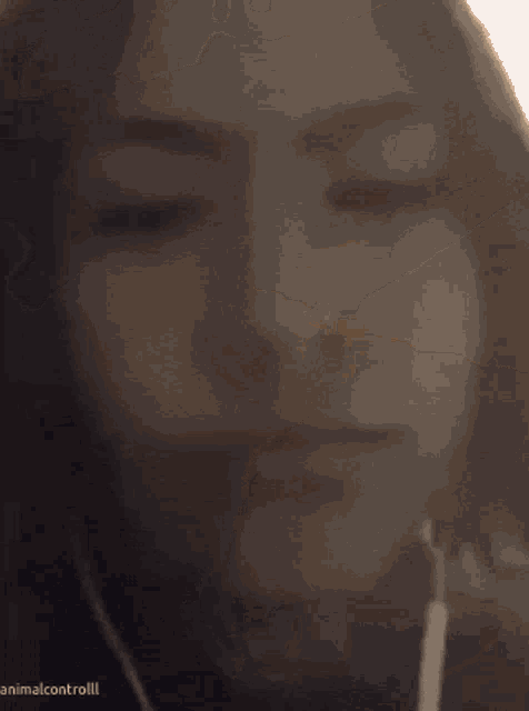 a blurred image of a woman 's face with the words animalcontrolll below her