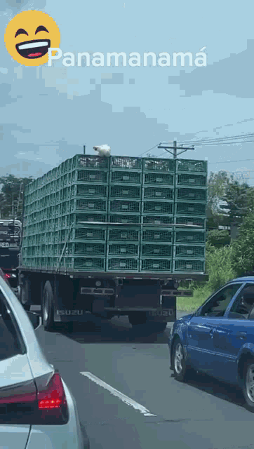 a truck with a bunch of green crates on the back is driving down a highway