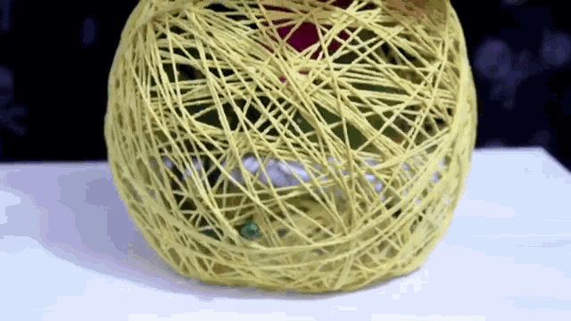 a yellow ball of yarn is sitting on a white table