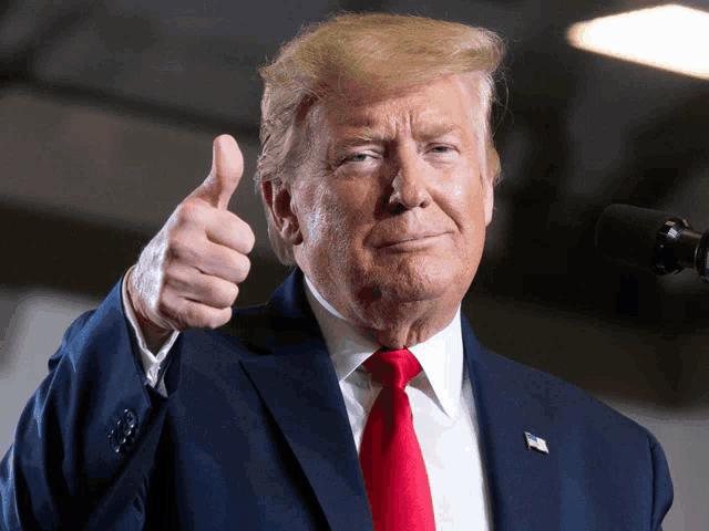donald trump giving a thumbs up while wearing a suit and tie