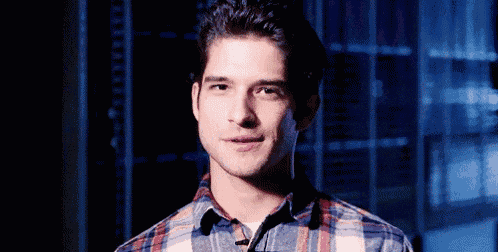a man wearing a plaid shirt is smiling and looking at the camera .