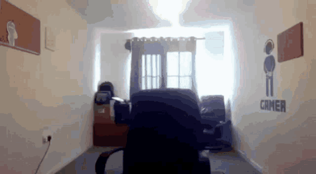 a room with a chair and a sign that says gamer on the wall