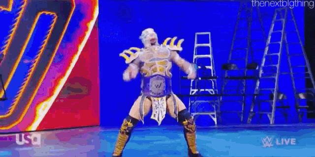a man in a wrestling outfit is dancing on a stage in front of a blue background .
