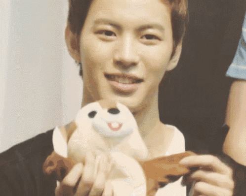 a man is holding a stuffed animal in his hands