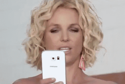 britney spears is taking a picture of herself with a cell phone .